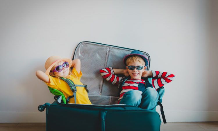 happy kids -boy and girl- enjoy packing and travel, family going on vacation