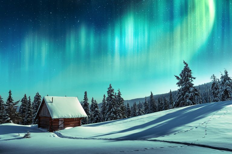 Northern lights above snowy landscape in Finland