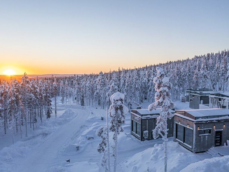 Rural villa in snowy Finland with a sunset in the background