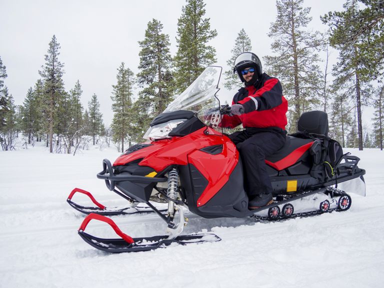 A Man On Snowmobile In Winter Mountain