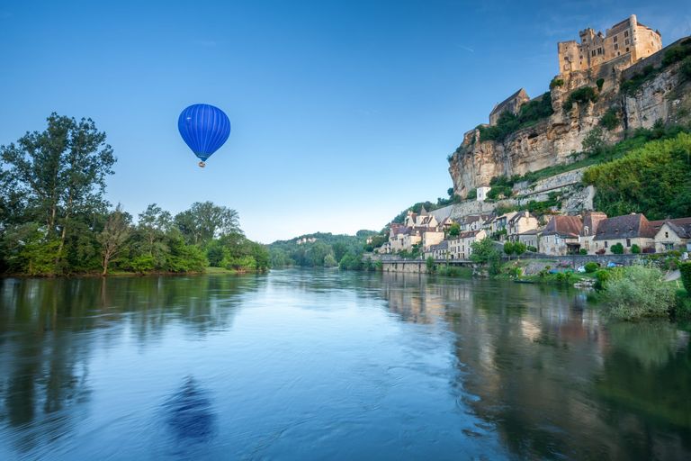 Hot air balloon above river in Dordogne