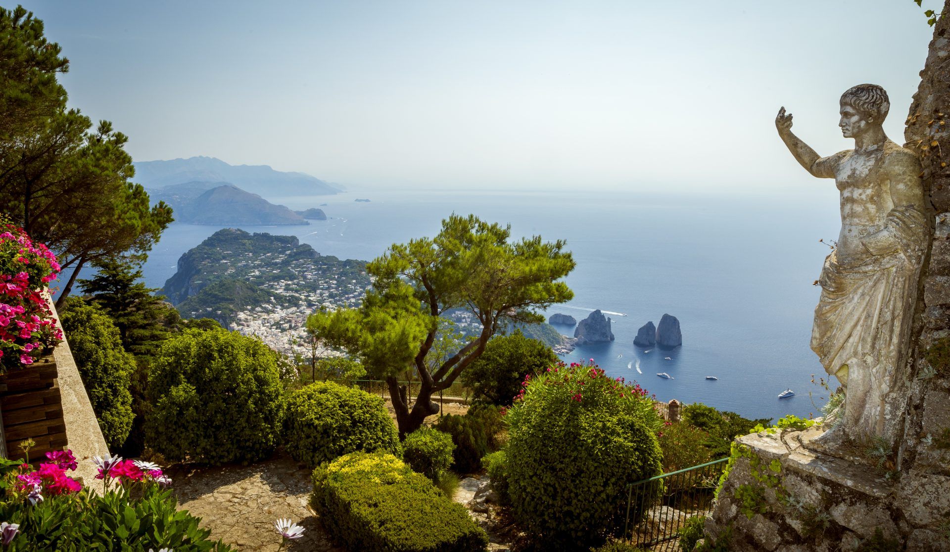 Statue on hillside looking over a bay in Capri