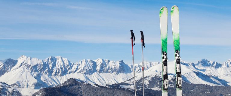 Skis posted into the ground with a backdrop of ski slopes in Combloux