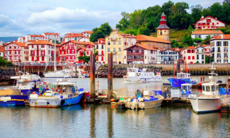 Boats in a harbour in front of colourful buildings