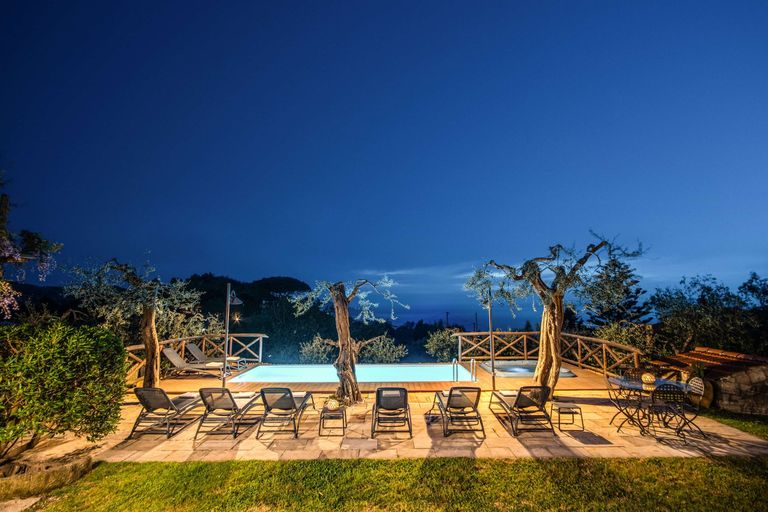 villa pool and sun loungers at dark
