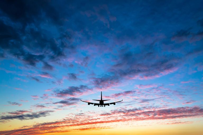 Plane flying at sunset
