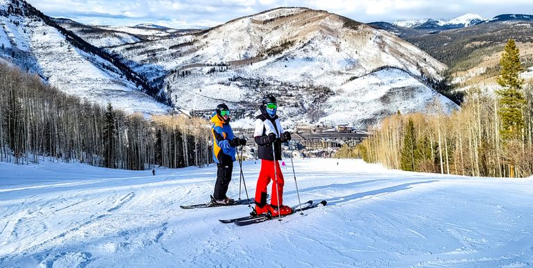 Two people posing whilst skiing in the mountains
