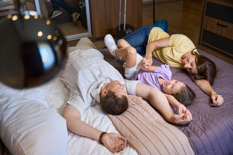 Happy family resting on a large bed