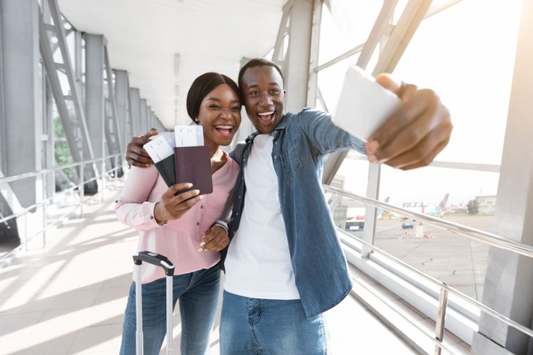 Cheerful couple taking selfie at an airport