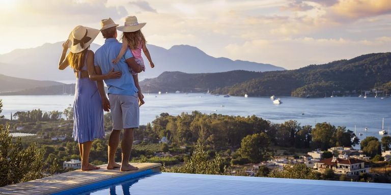 Family looking out to the coast, standing by an infinity pool