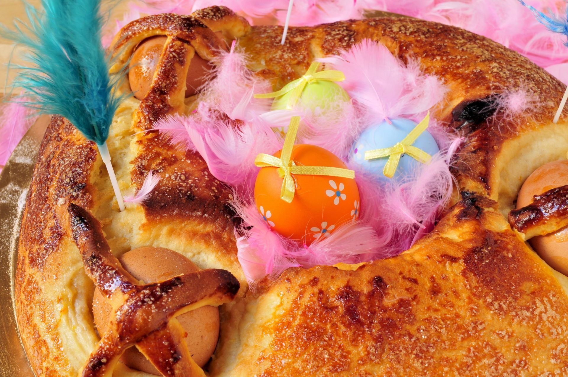 A traditional mona de pascua typical in Spain, a cake with boiled eggs eaten on Easter Monday, with some decorated eggs and feathers