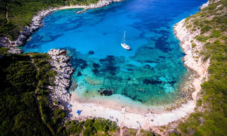 Porto Timoni, on of the hidden beaches of Corfu Island, also known as Kerkyra, near Agios Giorgios beach. Turqoise waters, summer aerial view from drone.