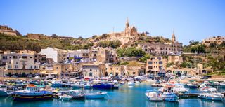 Beautiful view on Gozo island from a boat, postcard style, beautiful colors landscape, in the background you can see old buildings