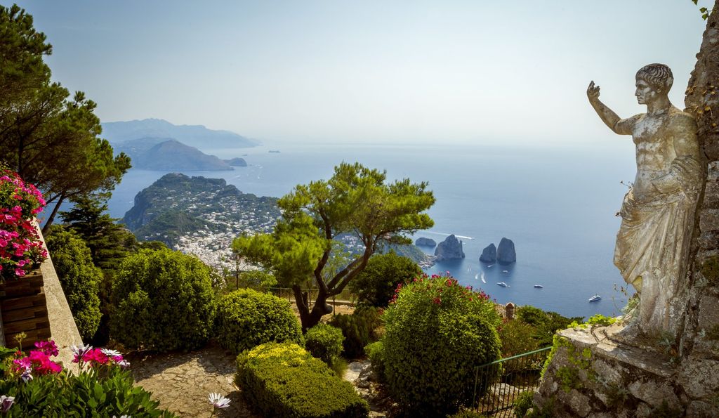 Statue on hillside looking over a bay in Capri
